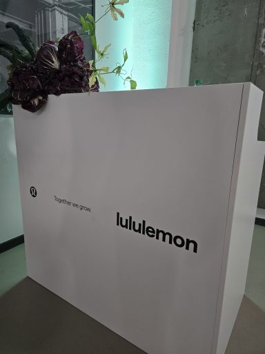 Weiße Verpackung mit lila Pflanzen und dem Logo von Lululemon.