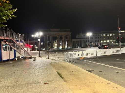 Brandenburger Tor bei Nacht, umgeben von Absperrungen und Straßenbeleuchtung.